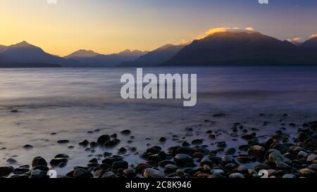 Rocky at the shore of Lake Te Anau at Department of Conservation, DOC, Henry Creek Campsite at sunset. Stock Photo