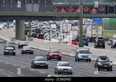 Autobahn A99 on July 25th, 2020 after the start of the summer holidays in Bavaria and Baden-Wuerttemberg. Heavy and stagnant traffic, traffic jams in the direction of Munich South on Hoehe Aschheim. A traffic bridge signals traffic jams ahead of the drivers. | usage worldwide Stock Photo