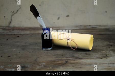 Vintage still life with paper, ink bottle and feather. Stock Photo