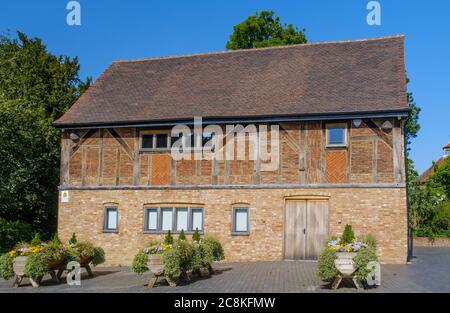 The Stables, 17th century timber framed building, with wooden planters, purple & yellow flowers & foliage, Eastcote House Gardens , Eastcote,  London. Stock Photo