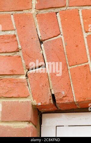 Broken brick arch, cracked mortar in brickwork above a window in a UK house. Home maintenance and repairs Stock Photo