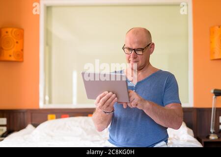 Senior handsome Scandinavian man relaxing inside the bedroom Stock Photo