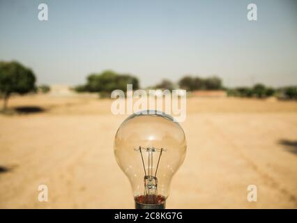 Old light bulb closeup in a desert Stock Photo