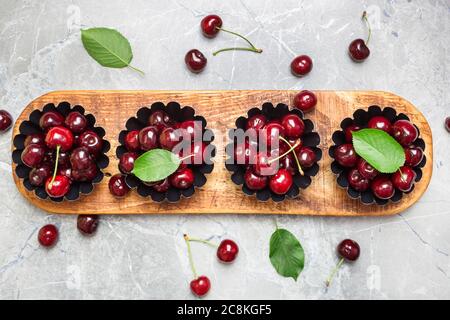 Flat lay composition with sweet cherries on marble table, space for text.