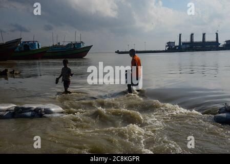 Dhaka, Bangladesh. 25th July, 2020. People walk through a submerged road.The flood situation is worsening in Munshiganj. Due to the heavy rain, the water level of the Padma River has risen which resulted in a flood. At least 1.5 million people have been affected, with homes and roads in villages flooded. Flood Forecasting and Warning Centre (FFWC) officials have reported, the flood situation in 15 northern and central districts due to the rise in the water level of the main rivers. Credit: SOPA Images Limited/Alamy Live News Stock Photo