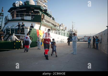 Algerian migrants wearing face masks disembark from a patrol vessel at Malaga port after being intercepted by Spanish Civil Guards authorities on the Mediterranean Sea.A Spanish Civil Guard vessel intercepted around 82 Algerian migrants near Almeria's coast while trying to reach Europe by small boats. During the coronavirus pandemic, the closure of Morocco's border with Spain as a measure to prevent the spread of coronavirus disease has caused a drastic drop in the number of migrants that try to reach the Spanish coasts across Alboran Sea route, while the arrival of migrants to Canary Islands Stock Photo