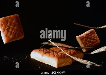 wheat and bread pieces on black background. Stock Photo