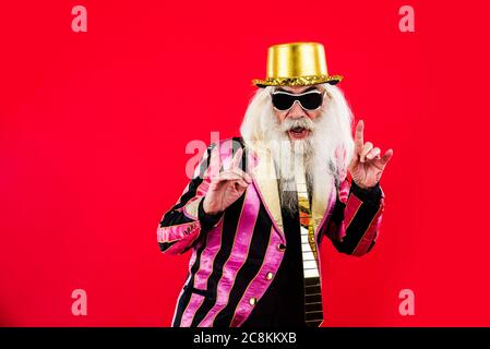Senior man with eccentric look  - 60 years old man having fun, portrait on colored background, concepts about youthful senior people and lifestyle Stock Photo