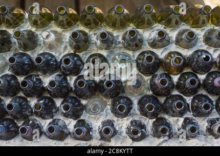 Green architecture: artistic glass bottles wall, made of recycled red and white wine bottles, and concrete Stock Photo