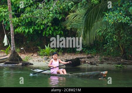 Rio Dulce, Guatemala - May 13, 2011: Young girl in a row boat, the typical form of transportation for Ketchi Indians living along the river. Stock Photo