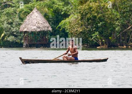 Rio Dulce, Guatemala - May 13, 2011: Young boy in a row boat, the typical form of transportation for Ketchi Indians living along the river. Stock Photo