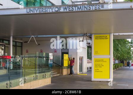 Two men fit a welcome poster at the main entrance to the University of Westminster, Marylebone Road, London, England, UK Stock Photo