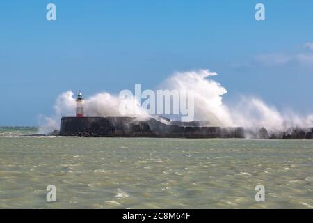 Waves crashing over the jetty and around the lighthouse, at Newhaven in Sussex Stock Photo