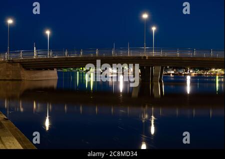 A long exposure shot of a calm bay area during night time. A bridge over a canal. Stock Photo