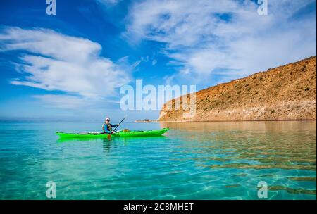 A woman sea kayaking off shore of  Isla Espirito Santo, Gulf of California, BCS, Mexico. Stock Photo