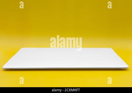 A rectangle empty white plate isolated on the yellow background. Stock Photo