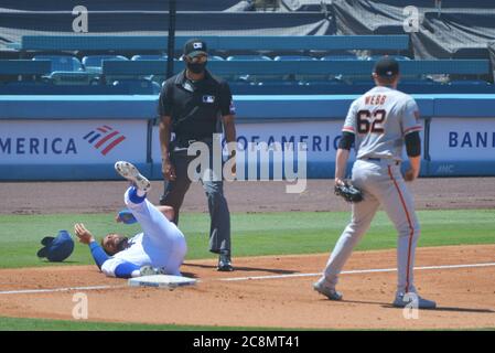 Los Angeles, United States. 26th July, 2020. Los Angeles Dodgers' Chris Taylor is thrown out attempting to advance to third base after a single by Joc Pederson when a throw from center field bounced away from the third baseman as starting pitcher Logan Webb looks on in the third inning at Dodger Stadium in Los Angeles on Saturday, July 25, 2020. The Giants defeated the Dodgers 5-4. Photo by Jim Ruymen/UPI Credit: UPI/Alamy Live News Stock Photo