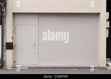 A closeup shot of automatic metal roller door used in factory, storage, garage, and industrial warehouse. The corrugated and foldable metal sheet offe Stock Photo