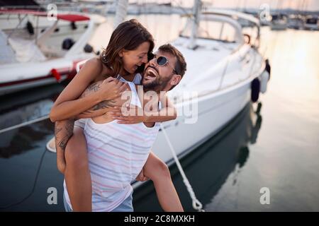 Young couple having fun in the dock on the sunset Stock Photo