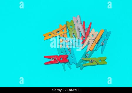 Colorful decorative wooden clothespins on turqoise background. Stock Photo