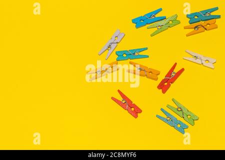 Colorful decorative wooden clothespins on yellow background. Stock Photo