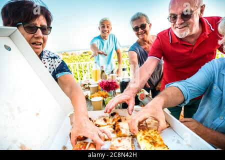 Group of cheerful friends have fun together in friendship taking and eating pizza food at home or outdoor party restaurant - concept of family and joy Stock Photo