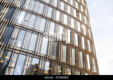Wide angle background image of graphic glass building front against clear sky with reflection in windows, copy space Stock Photo