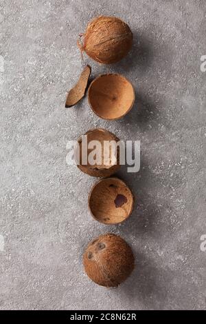 Coconuts whole and broken on gray concrete. Stock Photo