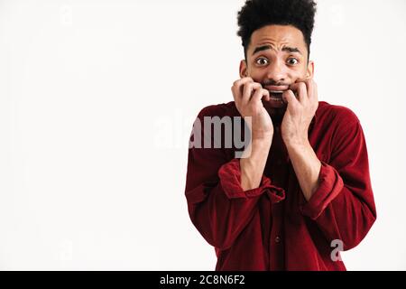 Photo of scared african young man posing isolated over white wall background Stock Photo