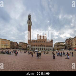 SIENA, ITALY - SEPTEMBER 24, 2017: The medieval city hall of the Palazzo Publico in Piazza del Campo on a cloudy September day Stock Photo