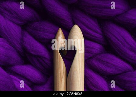 Two knitting needles with a cut in the form of a heart, lying on a merino wool, handmade, purple Stock Photo