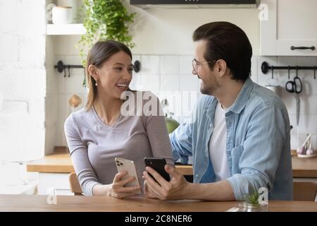 Smiling millennial couple have fun using cellphone gadgets Stock Photo