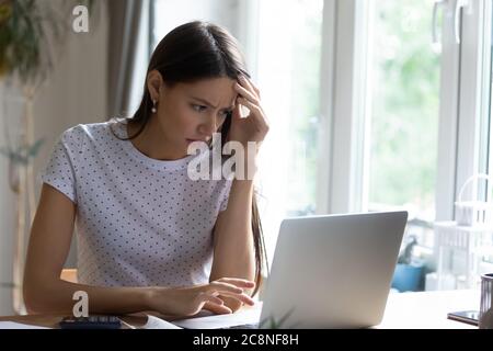 Unhappy young woman frustrated by computer problems Stock Photo