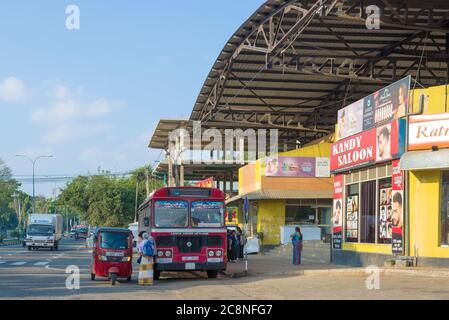 DAMBULLA, SRI LANKA - FEBRUARY 08, 2020: Red intercity bus and tuk-tuk at the intercity terminal Stock Photo