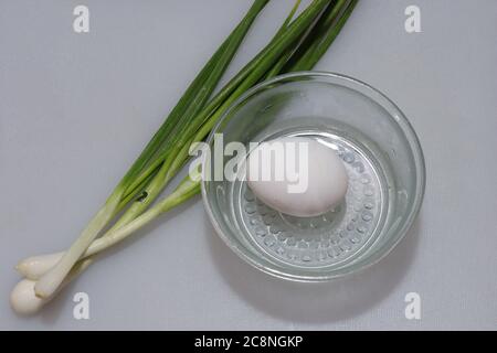 Fresh Green Spring Onion Roots with egg curry On An Isolated White Background Stock Photo