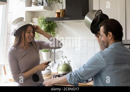 Happy playful young couple have fun in kitchen Stock Photo