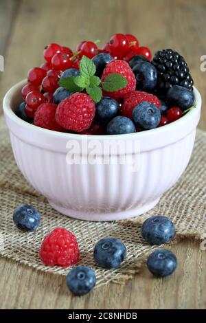 fresh raspberries, blueberries and red currants in bowl on the table Stock Photo