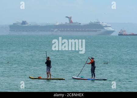 Weymouth, Dorset, UK.  26th July 2020.  UK Weather.   Holidaymakers on paddle boards enjoying themselves on the water at the seaside resort of Weymouth in Dorset on a morning of warm hazy sunshine.  Picture Credit: Graham Hunt/Alamy Live News Stock Photo