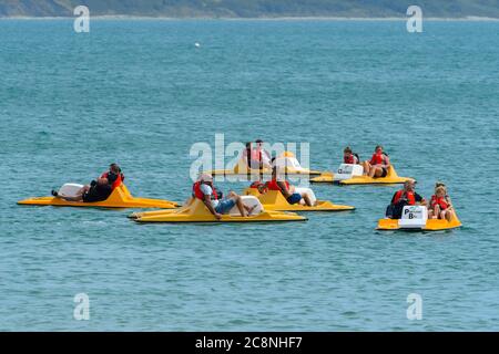 Weymouth, Dorset, UK.  26th July 2020.  UK Weather.   Holidaymakers on pedalos enjoying themselves on the water at the seaside resort of Weymouth in Dorset on a morning of warm hazy sunshine.  Picture Credit: Graham Hunt/Alamy Live News Stock Photo