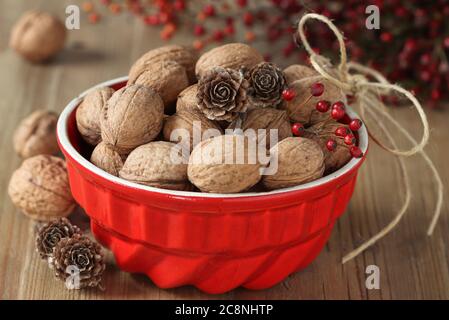 walnuts in red bowl on the wooden table Stock Photo