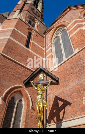 St Mary Magdalene Church, Paddington, London, completed in 1870s in packed slum area. WW1 memorial of Christ (cast iron & gilded) on wooden cross. Stock Photo