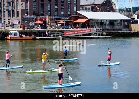 Summers day in by Bristol Harbourside. Stand Up Paddleboarding  or SUP on the water in front of the SS Great Britain Stock Photo