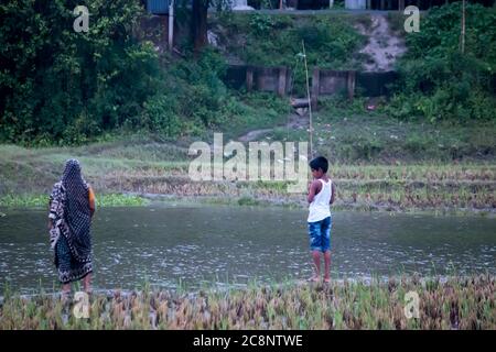 Little boy is fishing at sunset on the lake Stock Photo