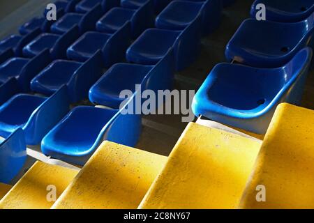 empty yellow and blue seats in a sports hall Stock Photo