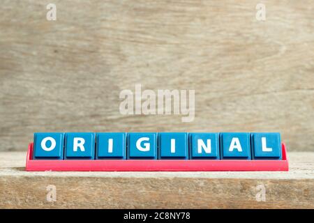 Tile letter on red rack in word original on wood background Stock Photo