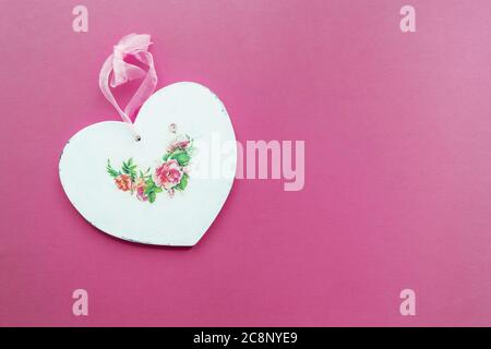 Valentine's card background - wooden heart decorated in decoupage technique Provencal style on a pink background with place for text. A nice gift for Stock Photo