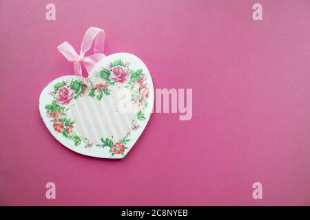 Valentine's card background - wooden heart decorated in decoupage technique Provencal style on a pink background with place for text. A nice gift for Stock Photo