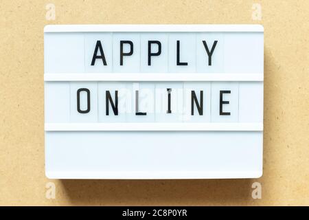 Lightbox with word apply online on wood background Stock Photo