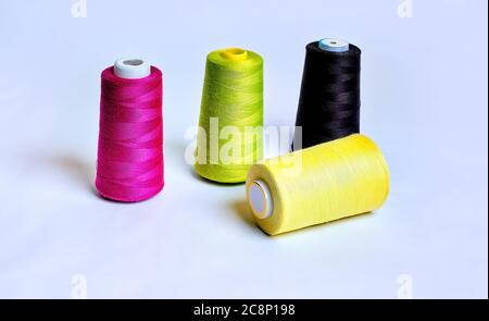Four sewing thread rolls in different colors isolated on white Stock Photo