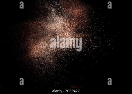 Abstract motion blurred brown sand background.Sandy explosion isolated on over dark background. Stock Photo